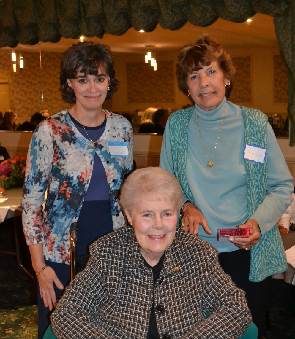 Three women posing for a picture at an event.
